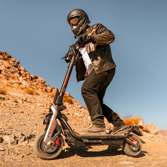 Person riding a Segway GT3 Pro Electric Scooter in a desert landscape with a clear blue sky
